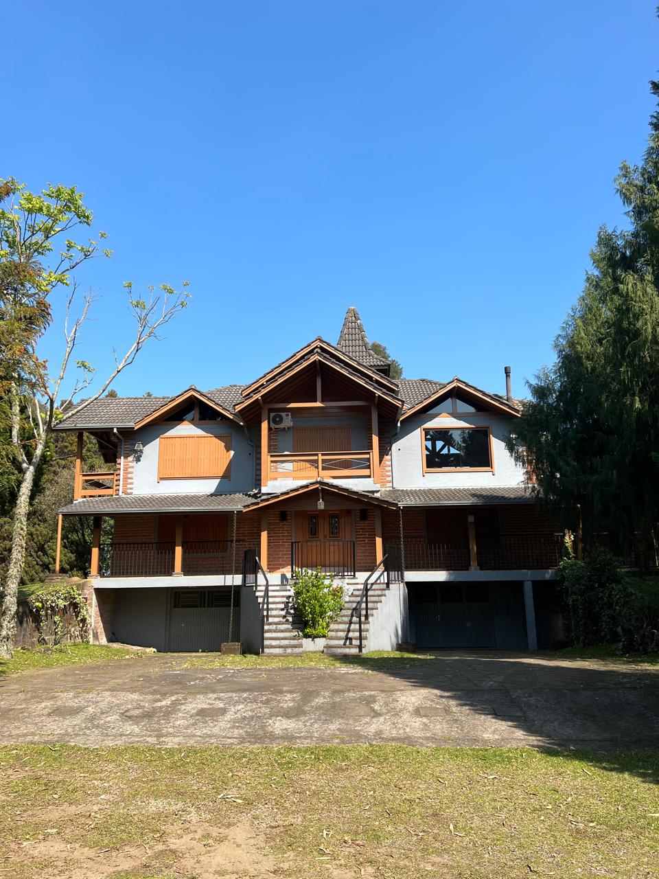 Casa do Ninho da Coruja vista de frente, com varanda e jardim